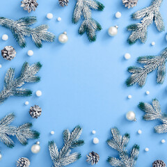 Christmas snowy decoration on classic blue background. Pine branch and cone, bauble and abstract...