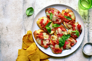 Grilled bruschetta with tomato and mozzarella. Top view with copy space.