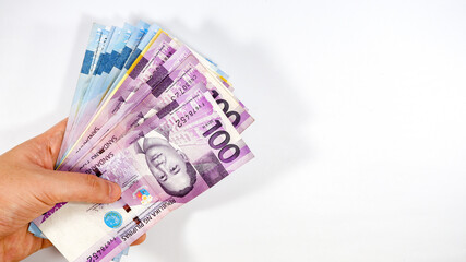 Paying and receiving of Philippine Peso bills as paycheck on white background
