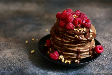 Delicious chocolate pancakes with fresh raspberries.