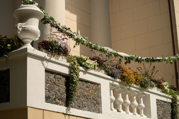 Floral decorations on palace balcony with balustrade and amphora.