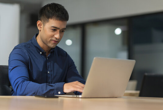 Young asian businessman working with laptop in office.