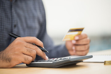 Fototapeta premium Close up businessman hand using calculator and holding credit card financial administration concept.