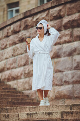 Charming girl in a bathrobe on a city street
