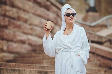 Charming girl in a bathrobe on a city street
