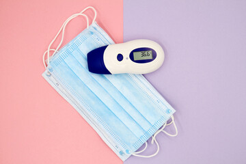 A non-contact infrared thermometer on the protective medical masks