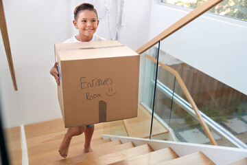 Hispanic Boy Carrying Box Into New Home On Moving Day
