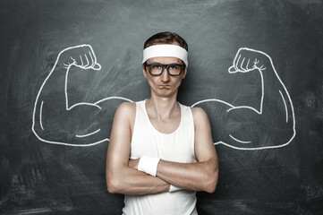 Funny sport nerd with fake muscle drawn on the chalkboard - obrazy, fototapety, plakaty