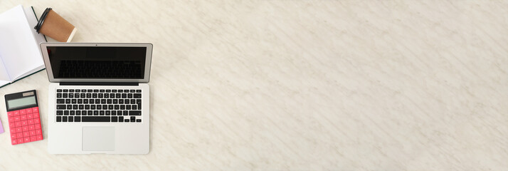 Modern workplace with laptop, cup of coffee and office supplies on light background with space for text