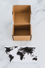 miniature postal parcel next to world map, global trade and worldwide deliveries
