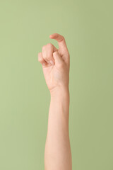 Hand showing letter X on color background. Sign language alphabet