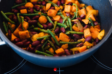 plant-based food, mixed vegetables getting sauteed in pan on stove