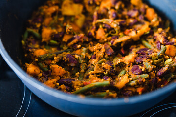 plant-based food, vegan mixed vegetables and red kidney beans getting sauteed in pan on stove