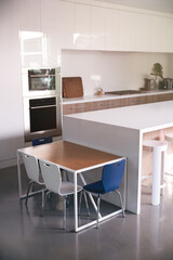 Interior View Of Beautiful Kitchen With Island Counter And Table For Children In New Family House