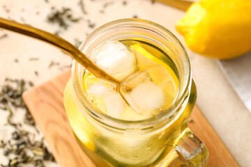 Mason jar of tasty cold ice tea on table, closeup