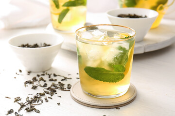 Glass of tasty cold ice tea on table