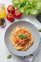 Traditional italian pasta spaghetti with bolognese meat sauce and parmesan on a light concrete, stone background