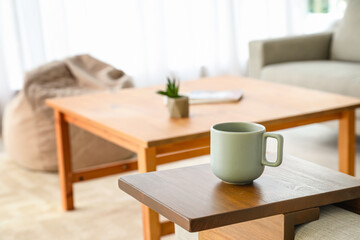 Fototapeta na wymiar Cup of tea on armrest table in room