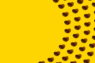 Creative bright collage of real macro photos of selected coffee beans on a yellow background with a hard shadow in the shape of a heart with a place for inscription.