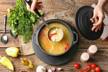 Woman pouring tasty rice soup from pot