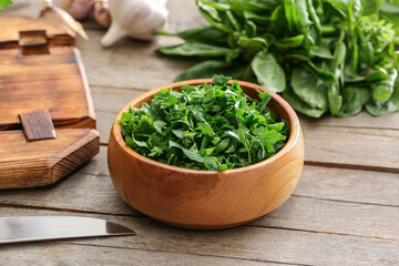 Bowl with fresh parsley on wooden table