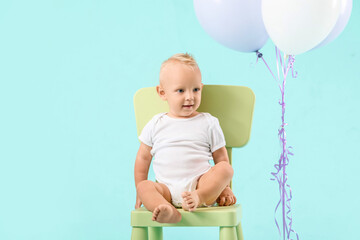 Portrait of cute little baby with air balloons on color background