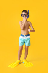 Little boy with snorkeling mask and paddles on color background