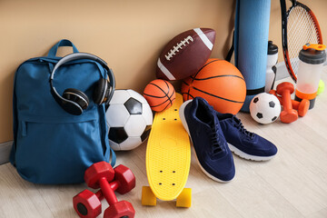 Set of sport equipment on floor near color wall