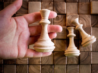 handmade wooden chess pieces on wooden board
