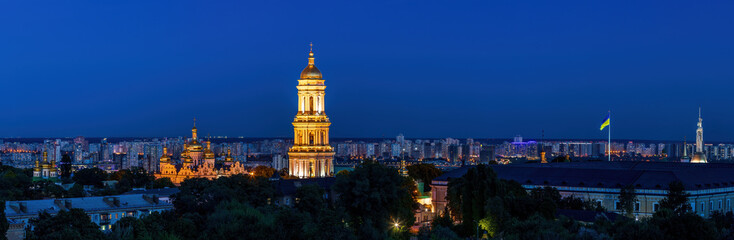 Fototapeta na wymiar View to the Bell Tower of Kyiv Pechersk Lavra and cityscape behind of it at sunset.