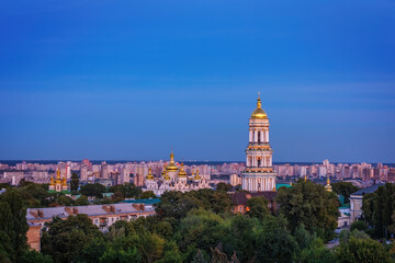 View to the Bell Tower of Kyiv Pechersk Lavra  and cityscape behind of it at sunset.