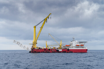 A typical derrick pipelay barge with 3000 metric tonne crane at an oil field during an overcast...