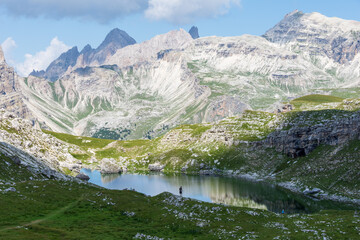 Naklejka na ściany i meble Panoramic view over Crespeina Lake, a pristine Alpine lake located at an altitude of 2300m (7500ft) in the Puez-Odle mountain range in a cloudy summer day. South Tyrol, Italy