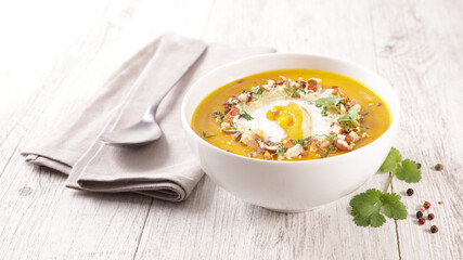 pumpkin soup with cream on wood background