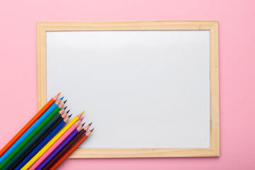 colorful pencils near empty white frame