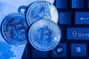 Image of bitcoin and money lying on the keyboard