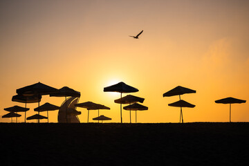 Sunrise with sunshade and life guard station silhouette