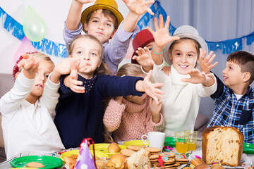 european children having celebration of friend birthday during dinner