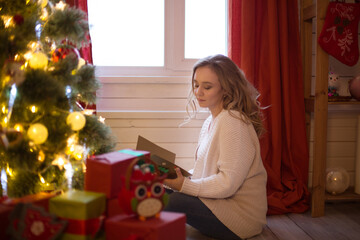 Fototapeta na wymiar Beautiful, young woman decorating a Christmas tree at home
