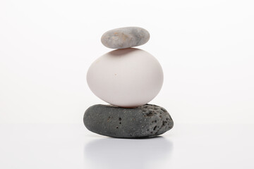 White egg and zen stones  on white background