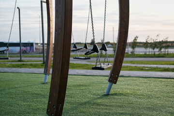 Empty Swings on the open air playground in park