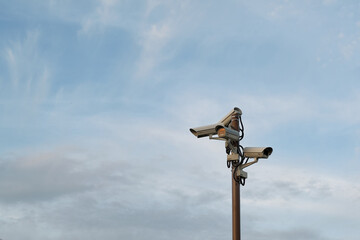 Security cameras on the pillar. cloudy evening sky on background.