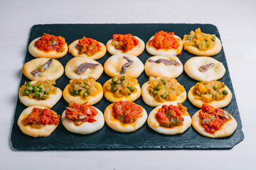 Many baked mini pizzas сocas. Traditional Spanish pastry with vegetables.