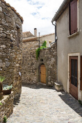 Fototapeta na wymiar The medieval stone architecture and the old narrow street of Minerve, the most beautiful medieval village of France, located in the picturesque mountain valley in Pyrenees