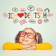 Beautiful cute little girl with eyeglasses looking at ich liebe deutch text and illustrations. English: i love german.  Foreign language learning concept.
 - obrazy, fototapety, plakaty
