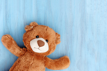 Cute teddy bear on blue wooden backdrop