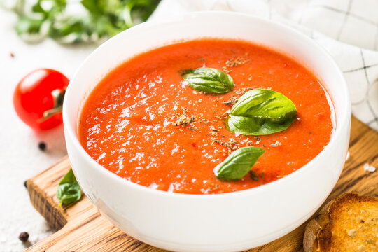 Tomato soup at white table.