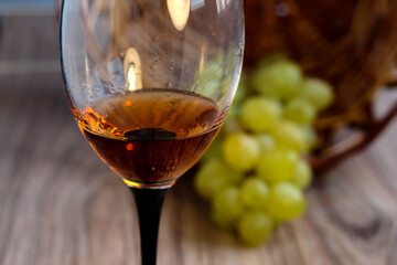 Wine glass with grapes on a wooden background.