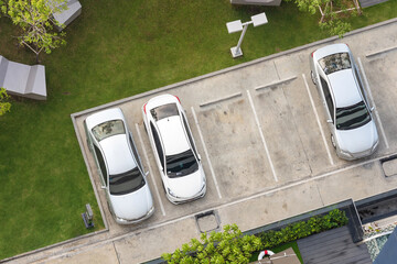 Top view of parking area with small garden in modern building - obrazy, fototapety, plakaty