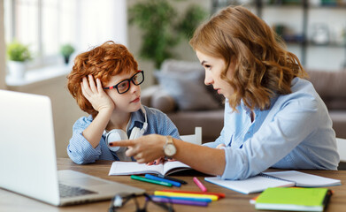 Mother helping child with online lesson at home.